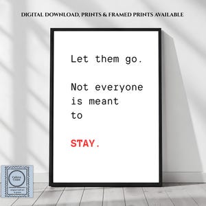 以下が含まれることがあります： 白い背景に黒い文字で「Let them go. Not everyone is meant to STAY.」と書かれた額縁入りのウォールアートプリント。STAYという単語は赤色で印刷されています。フレームは黒い長方形で、シンプルで清潔感のあるスタイルで提示されています。