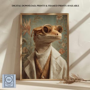 May include: A framed wall art print featuring a lizard wearing round glasses, a cream turtleneck, a brown knit cardigan, and a cream blazer. The background shows floral patterns. Text at the top reads: DIGITAL DOWNLOAD, PRINTS & FRAMED PRINTS AVAILABLE.