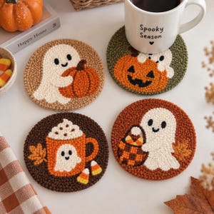 May include: Four round punch needle coasters featuring Halloween designs. One shows a ghost with a pumpkin, another a jack-o'-lantern with a ghost, one a ghost in a mug with whipped cream, and the last a ghost with a basket of candy corn.
