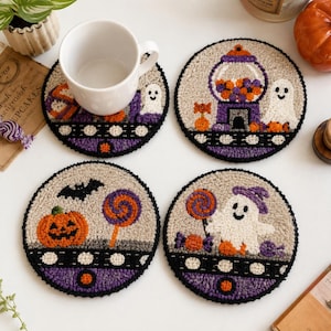 May include: Four round punch needle coasters featuring Halloween designs. Each coaster has a beige background, a black and purple border, and motifs including ghosts, jack-o'-lanterns, gumball machines, bats, and colorful lollipops with candy.