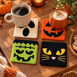 Puede incluir: Un juego de cuatro posavasos cuadrados de punch needle con diseños de Halloween: un fantasma crema, una calabaza naranja, un monstruo de Frankenstein verde y una cara de gato negro con ojos amarillos. Cada posavasos tiene una superficie de lana texturizada.