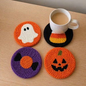 May include: Set of four Halloween-themed coasters. One coaster features a white ghost on an orange background. Another has a candy corn design. The other two coasters have a candy and a jack-o'-lantern design. A white mug with a beverage sits on one coaster.