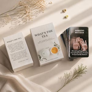 May include: A deck of cards titled What's The Tea, featuring a white box with a teapot and teacup illustration, a descriptive back panel, and a card showing hands with the text Dodging Bullets, Blocking Negativity, Escaping Crazy People, Protected By Haters.