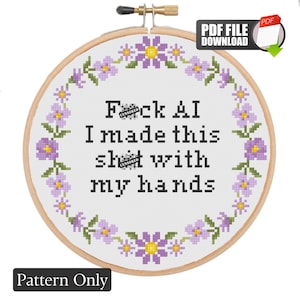 May include: A cross-stitch pattern in a wooden embroidery hoop featuring a floral wreath of purple and yellow flowers surrounding the black text: F*ck AI I made this sh*t with my hands. The design is presented as a digital PDF download file.