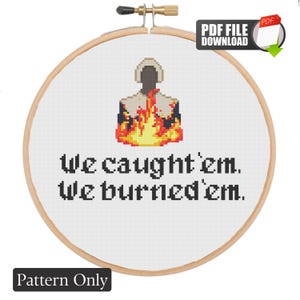 May include: A cross-stitch pattern in a wooden embroidery hoop featuring a pixelated figure in a white bonnet surrounded by orange and yellow flames. Below the figure, the black text reads: We caught 'em. We burned 'em. This is a digital PDF file.