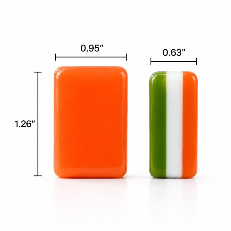 May include: Two rectangular resin tiles. The left tile is solid orange, measuring 0.95 inches wide by 1.26 inches high. The right tile features vertical stripes of green, white, and orange, with a width of 0.63 inches. Both have rounded corners.