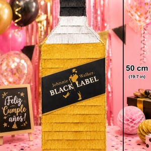 May include: A large, yellow pi&ntilde;ata shaped like a Johnnie Walker Black Label bottle, measuring 19.7 inches tall. The label reads "Johnnie Walker BLACK LABEL" and "DANILO (33) A&Ntilde;OS". The pi&ntilde;ata is decorated for a birthday celebration.