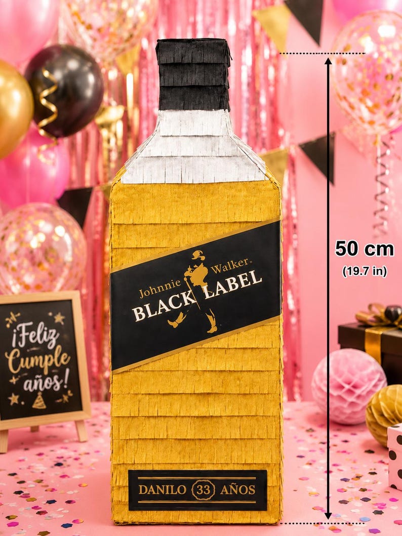 May include: A large, yellow pi&ntilde;ata shaped like a Johnnie Walker Black Label bottle, measuring 19.7 inches tall. The label reads "Johnnie Walker BLACK LABEL" and "DANILO (33) A&Ntilde;OS". The pi&ntilde;ata is decorated for a birthday celebration.