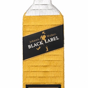 May include: A large, rectangular pi&ntilde;ata shaped like a Johnnie Walker Black Label bottle. The pi&ntilde;ata is primarily gold with a black label featuring the brand's logo and text. The top is black and white, and the bottom has text that reads "DANILO (33 A&Ntilde;OS".