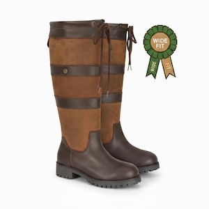 May include: A pair of knee-high boots in two-tone brown leather featuring dark brown horizontal straps, a lace-up detail at the top, and a lug sole. A green circular badge with the text WIDE FIT is positioned to the right of the boots.
