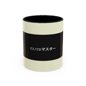 May include: A ceramic coffee mug with a black interior and a cream-colored exterior. A black band wraps around the middle of the mug, displaying the text "CI/CD マスター" in white. The mug is designed for hot beverages.