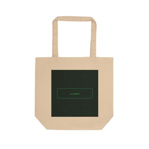 May include: Beige tote bag with a dark green rectangular graphic. The graphic has a green outlined rectangle with Japanese text inside. The bag has two beige handles.