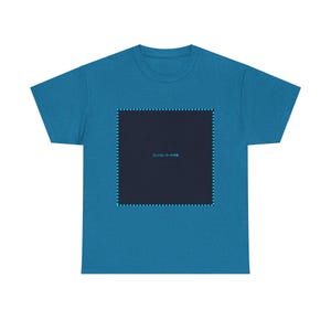 May include: Teal t-shirt featuring a dark blue square graphic with a dotted border and Japanese text. The shirt is made of a soft material. A casual, everyday garment.