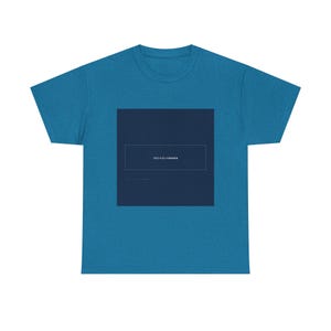 May include: A teal t-shirt featuring a dark blue square with a white rectangular border. Inside the square is Japanese text. The shirt is made of a soft material and has a classic crew neck.