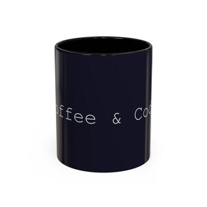 以下が含まれることがあります： 白い文字で「Coffee & Code」と書かれた黒いコーヒーマグ。マグカップの内側は黒く、光沢のある仕上がりです。マグカップは円筒形で、セラミック製と思われます。
