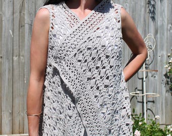 May include: A light gray crochet vest with a V-neck and a wrap-around design. The vest is sleeveless and has a delicate, openwork pattern.