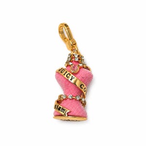 May include: A gold-tone metal charm shaped like a dress form, featuring a pink velvet-textured torso, clear rhinestones, and gold ribbons inscribed with the text JUICY CO and glam. The charm includes a lobster claw clasp at the top for attachment.