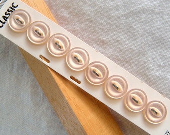 Könnte beinhalten: Eine Karte mit acht weißen Knöpfen mit jeweils zwei Löchern. Auf der Karte steht "CLASSIC" und "606 273215" gedruckt. Die Karte hat auch den Text "SIZE 1/2 COUNT 8 WASHABLE" aufgedruckt.