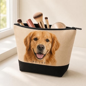 Può includere: Una pochette cosmetica con cerniera beige e nera con il ritratto stampato di un cane golden retriever e il nome BAILEY scritto in lettere maiuscole nere sotto il mento del cane. La pochette contiene vari pennelli da trucco e un compatto.