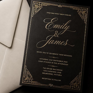 Op de afbeelding: Een zwarte trouwkaart met gouden letters en geometrische randdetails. De tekst luidt: Together with their families, Emily & James, invite you to celebrate their wedding, Saturday, 21st September 2024, four o'clock in the afternoon, The Grand Ballroom, 1234 Elegance Lane, Melbourne, Victoria, reception to follow. Een witte envelop ligt aan de linkerkant.