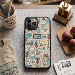 May include: A phone case with a black border featuring a pattern of Dunder Mifflin-themed illustrations, including beets, teapots, and the text "That's What She Said." A "World's Best Boss" mug and a "Dundie Award" trophy are also visible.