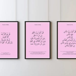 Puede incluir: Tres impresiones enmarcadas con marcos negros y fondos rosas. Cada impresión presenta caligrafía árabe en negro. Las impresiones se muestran en una pared blanca. El texto de las impresiones está en árabe.