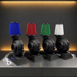 Könnte beinhalten: Vier schwarze Lampen in Turbinenform mit farbigen Luftfiltern: blau, rot, grün und weiß. Jede Lampe steht auf einem abgestuften Sockel mit dem Aufdruck "JORDY" auf der Vorderseite. Ein weißes USB-Kabel ist an einer Lampe angeschlossen.
