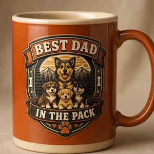 Può includere: Una tazza in ceramica color arancio bruciato con una grafica centrale che mostra un cane adulto e tre cuccioli davanti a montagne e alberi. Il testo recita BEST DAD IN THE PACK, accompagnato da icone di ossa e un'impronta di zampa.