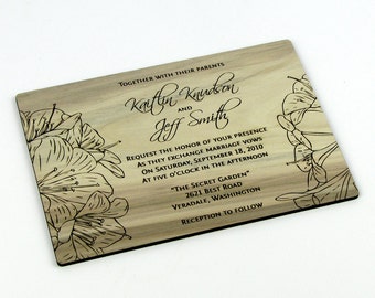 May include: A wooden wedding invitation with a floral design and the text "Together with their parents Kaitlin Knudson and Jeff Smith Request the honor of your presence as they exchange marriage vows on Saturday, September 18, 2010 at five o'clock in the afternoon "The Secret Garden" 2621 Best Road Veradale, Washington Reception to follow"