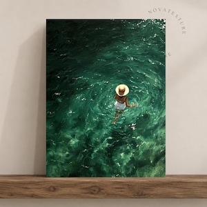 May include: A rectangular wall art print featuring a high-angle view of a person wearing a straw hat and white clothing wading in deep emerald green water. The surface of the water shows ripples and light reflections. The text NOVATEXTURE is visible.
