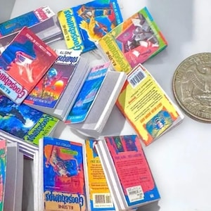Puede incluir: Una colección de libros en miniatura de "Goosebumps" con cubiertas coloridas, que presentan varias ilustraciones y títulos. Se incluye una moneda de 25 centavos estadounidense para comparar el tamaño. Los libros están dispuestos en un montón.