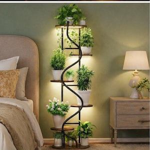 May include: A tall, black metal plant stand with multiple wooden shelves, each holding potted plants. A spiraling black metal accent runs along the center. The stand is illuminated with warm lighting, creating a cozy atmosphere. The plants vary in size and type, adding a touch of nature to the room.