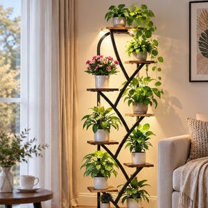 May include: A tall, black metal plant stand with a curved, leaf-like frame and multiple wooden shelves. The stand holds various green potted plants and a pot of pink flowers. Integrated lighting illuminates the shelves from above, creating a warm glow.