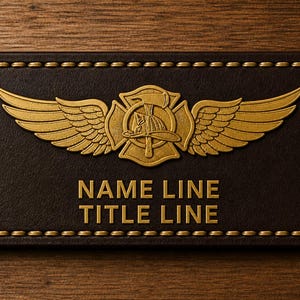 May include: A rectangular, brown leather name tag with gold-colored stitching and a gold emblem. The emblem features a firefighter's helmet, axe, and wings. The text "NAME LINE" and "TITLE LINE" are in gold.