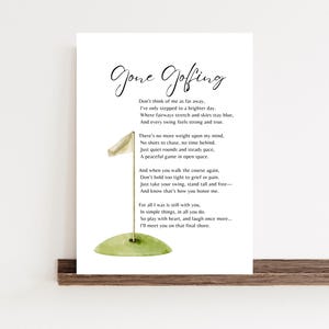 Peut inclure: Impression encadrée avec l'inscription "Gone Golfing" en écriture élégante. L'œuvre présente une illustration à l'aquarelle d'un green de golf avec un drapeau. Le poème est imprimé en noir sur fond blanc.