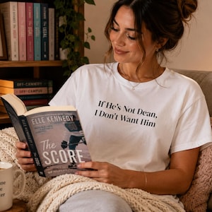 May include: A white short-sleeved t-shirt featuring the black printed text If He's Not Dean, I Don't Want Him centered on the chest. The shirt is made of a lightweight fabric and has a classic crew neckline with a standard fit and hemmed sleeves.