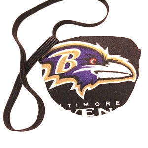 May include: Black eye patch with an embroidered Baltimore Ravens logo. The logo features a purple raven with a gold "B" on its chest and the words "Baltimore Ravens" below.