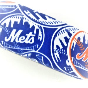 Op de afbeelding: Een blauw en wit brillenkoker van het honkbalteam Mets. De koker heeft het logo van het team, inclusief het woord "Mets" in wit en oranje, en een stadsgezichtontwerp. De koker is cilindrisch van vorm.