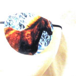 May include: A blue and brown eye patch with a horse design. The patch has an elastic strap.