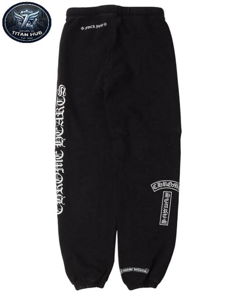 May include: Black sweatpants with white "CHROME HEARTS" lettering down the left leg and on the right leg. The text "Fuck You" is printed on the upper back. The sweatpants have a drawstring waist and elastic cuffs.