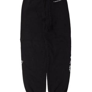 May include: Black sweatpants with a drawstring waist and white text on the side and upper right leg. The pants have a relaxed fit and a logo patch near the left pocket. The text "CHROME HEARTS" is visible on the upper right leg.