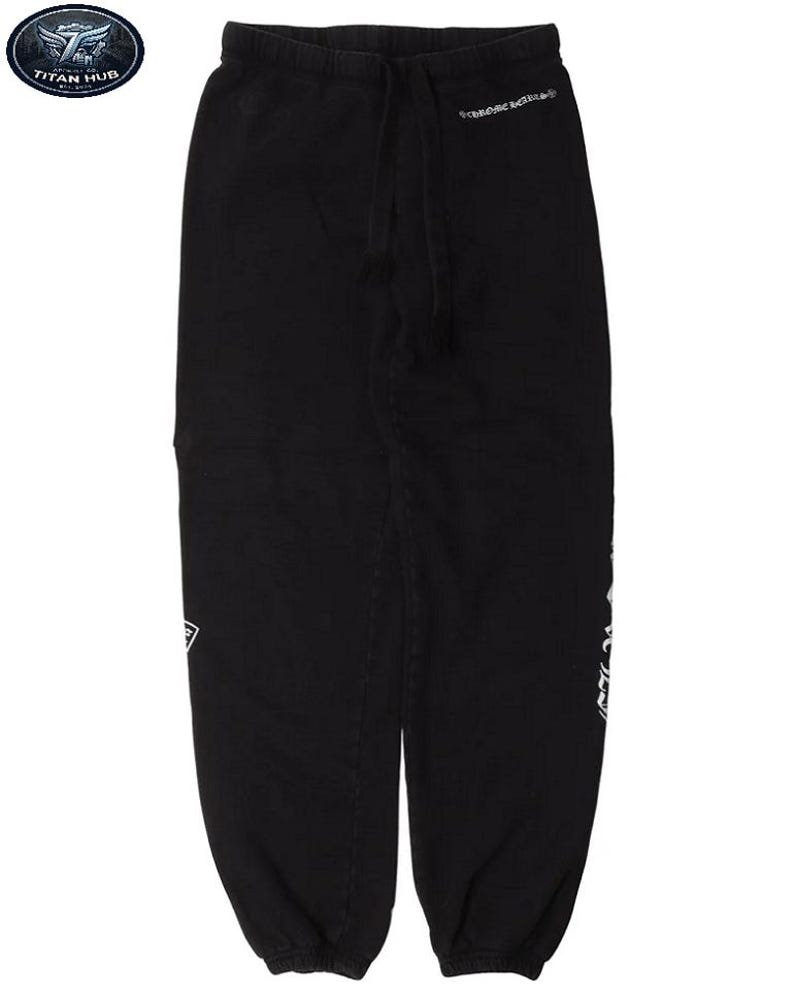 May include: Black sweatpants with a drawstring waist and white text on the side and upper right leg. The pants have a relaxed fit and a logo patch near the left pocket. The text "CHROME HEARTS" is visible on the upper right leg.