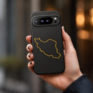 May include: A matte black smartphone case featuring a thin, golden-yellow outline of the map of Iran centred on the back. The case has a horizontal camera bar cutout at the top, revealing three circular camera lenses and a small flash component.