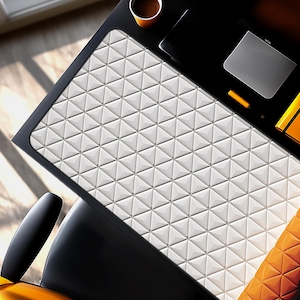 May include: A modern black desk with a white geometric patterned surface. A laptop, pen, and a cup of coffee are on the desk. The chair is black with an orange seat.