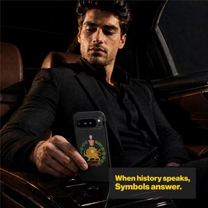 Puede incluir: Una funda de smartphone negra con un emblema dorado de un le&oacute;n y un sol rodeado por una corona de laurel verde y una corona roja. El texto en la pantalla dice, When history speaks, Symbols answer. Tiene una abertura para la c&aacute;mara.
