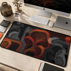 May include: A rectangular desk mat featuring an abstract design of flowing, tree-like structures in shades of orange, red, white, and black. The pattern consists of fine, radiating lines and dense clusters of dots that create a textured, organic appearance.
