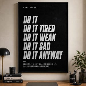 Könnte beinhalten: Ein schwarz gerahmter Wandkunstdruck mit weißem Text: CONSISTENCY, DO IT, DO IT TIRED, DO IT WEAK, DO IT SAD, DO IT ANYWAY und CONSISTENCY DOESN'T GUARANTEE SUCCESS BUT, INCONSISTENCY GUARANTEES FAILURE, auf einem dunklen Hintergrund.