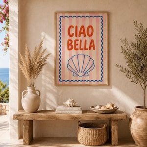 Könnte beinhalten: Ein rechteckiges gerahmtes Wandbild mit vertikalen hellrosa und weißen Streifen, einem blauen Wellenrand und dem orangefarbenen Text "CIAO BELLA" über einer blauen Strichzeichnung einer Muschel, die mittig auf dem hellen Hintergrund platziert ist.