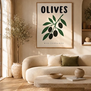 Könnte beinhalten: Ein rechteckiger Wandkunstdruck in einem hellen Holzrahmen mit dem Wort OLIVES in fetten schwarzen Buchstaben oben und dem Wort MEDITERRANEO in kleinen schwarzen Buchstaben unten, mit einer zentralen Grafik eines grünen Olivenzweigs.