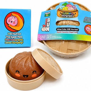 May include: A brown squishy dumpling toy with a smiling face, inside a beige container. The packaging includes a blue box with text: "Will You Find The Super Rare Pink Holographic Glitter Dumpling?" and a bamboo steamer-style container.
